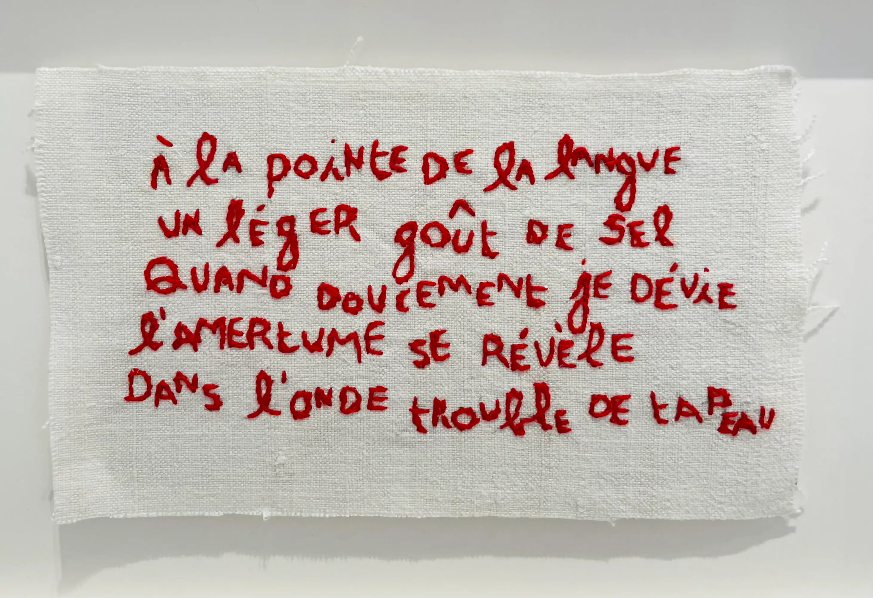 À la pointe, vers originaux brodés à la main au fil rouge sur drap de lin ancien. Oeuvre d'art textile contemporain de l'artiste Mai Khanh Pham To