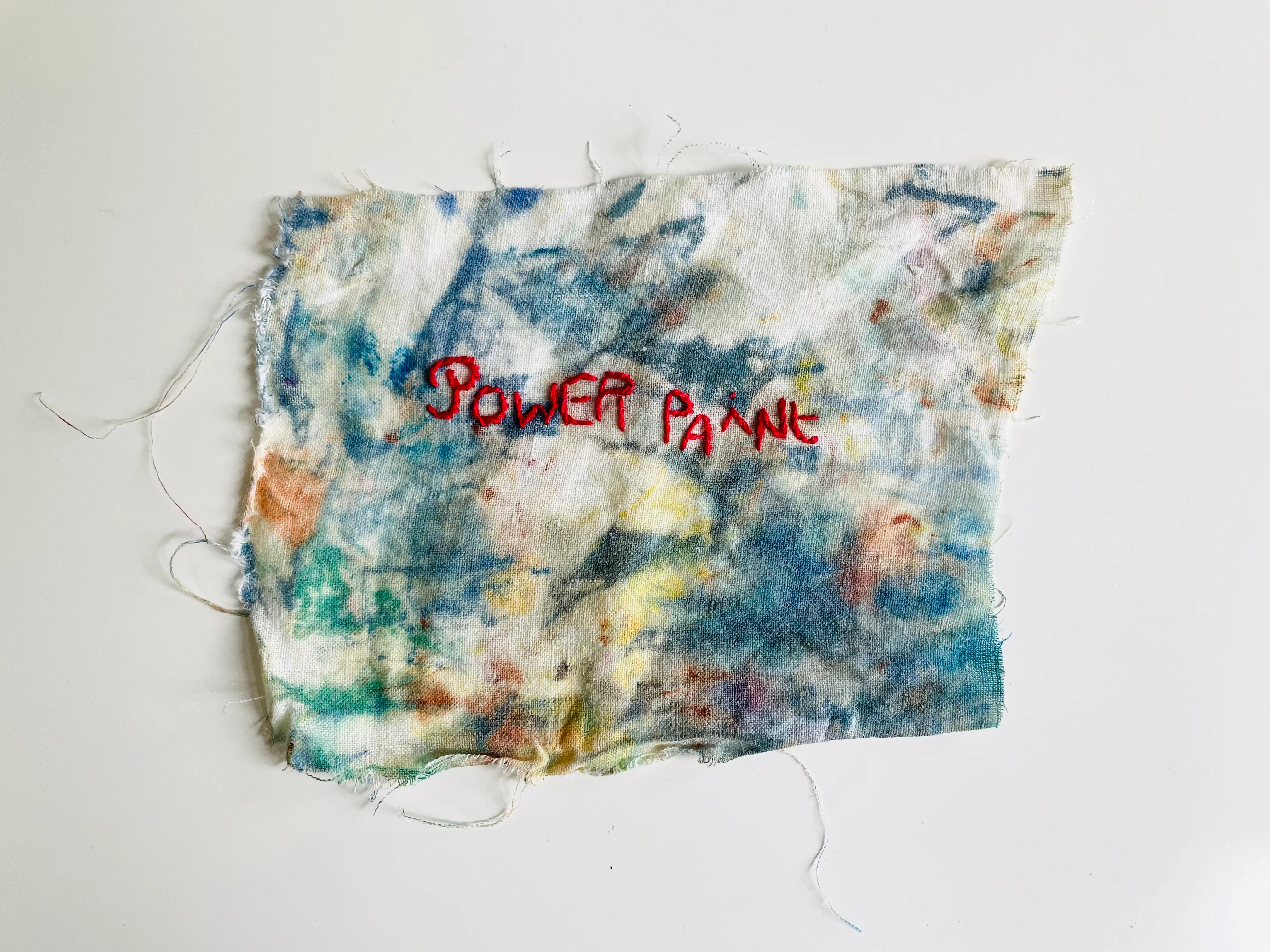 Power Paint, texte brodé à la main au fil rouge sur drap de lin ancien avec tâches colorées de peinture. Oeuvre d'art textile contemporain de l'artiste Mai Khanh Pham To