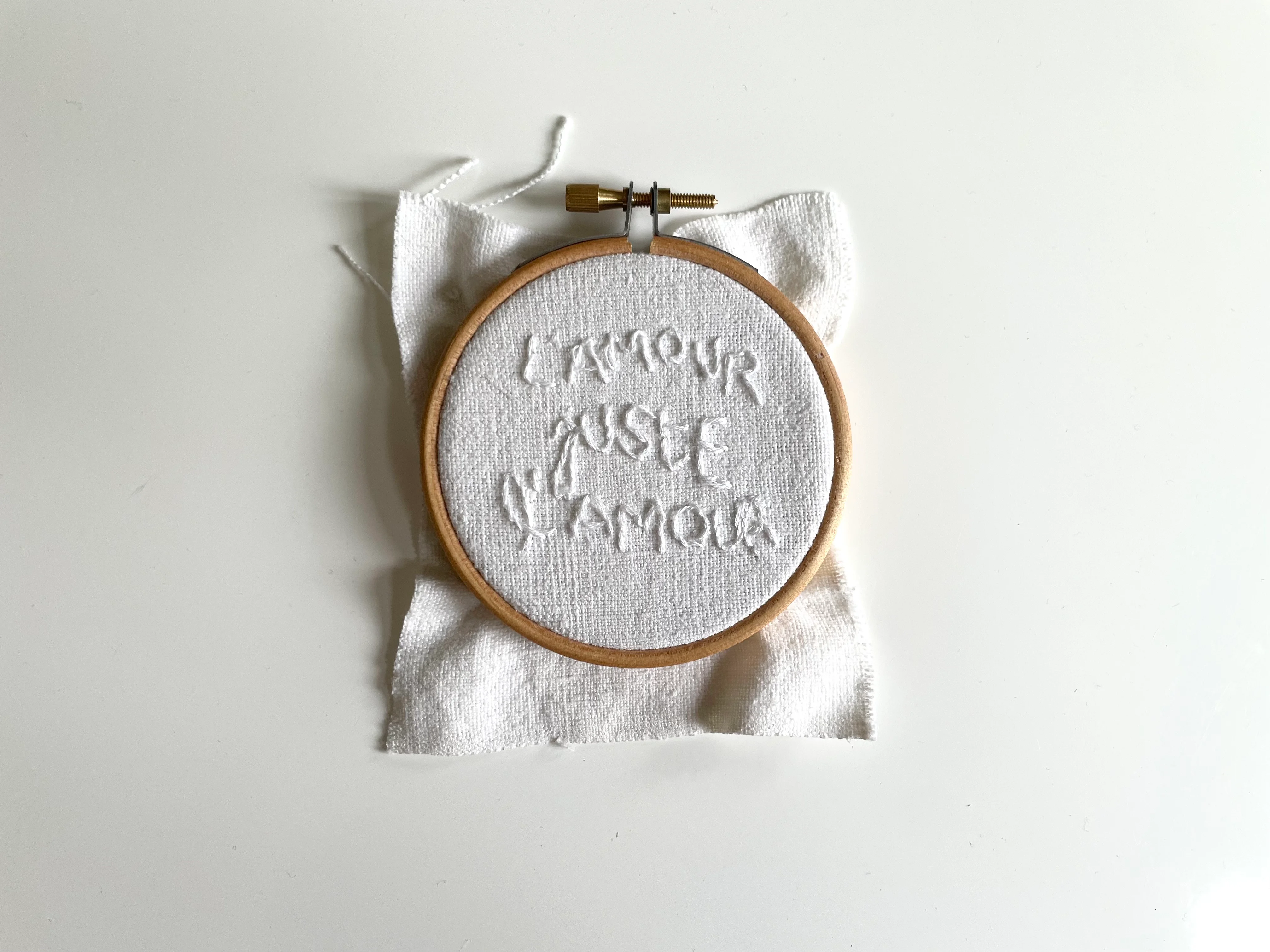 Le secret de l'amour, texte "L'amour juste l'amour" brodé à la main au fil blanc sur drap de lin blanc ancien