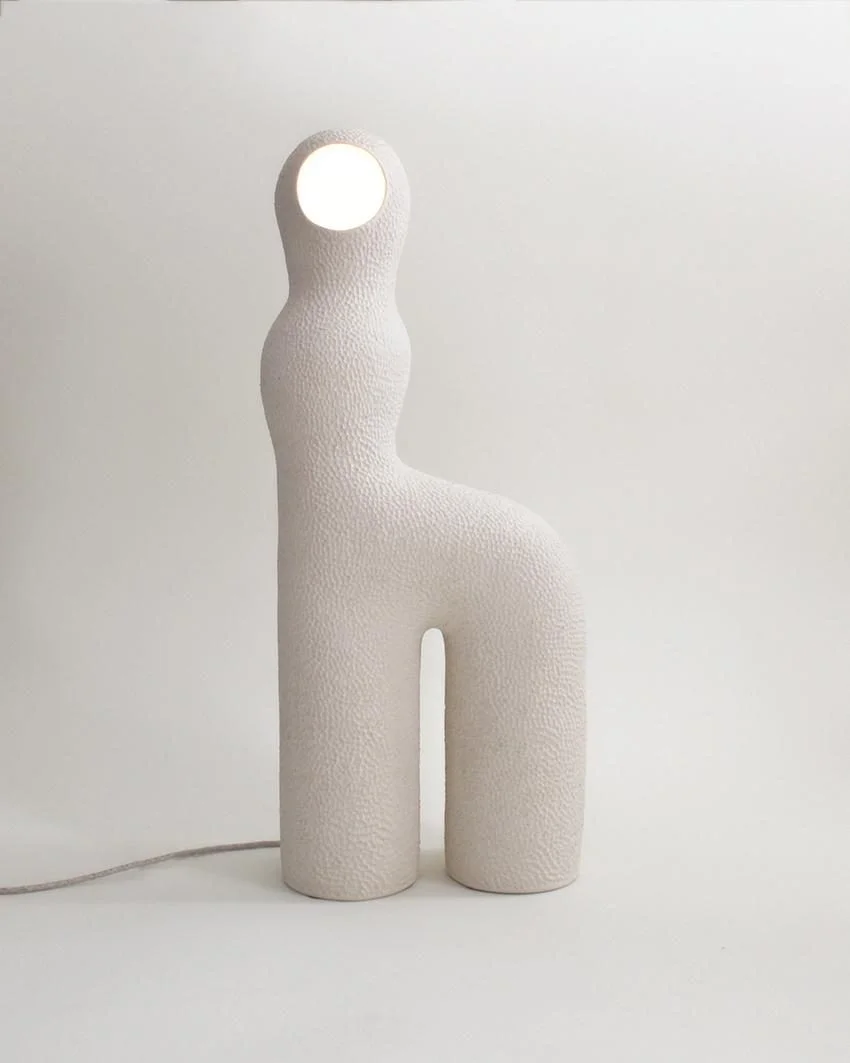 Lampe Infini #5 d'Elisa Uberti en grès blanc, texturé, silhouette anthropomorphe avec une ouverture ronde lumineuse en guise de tête