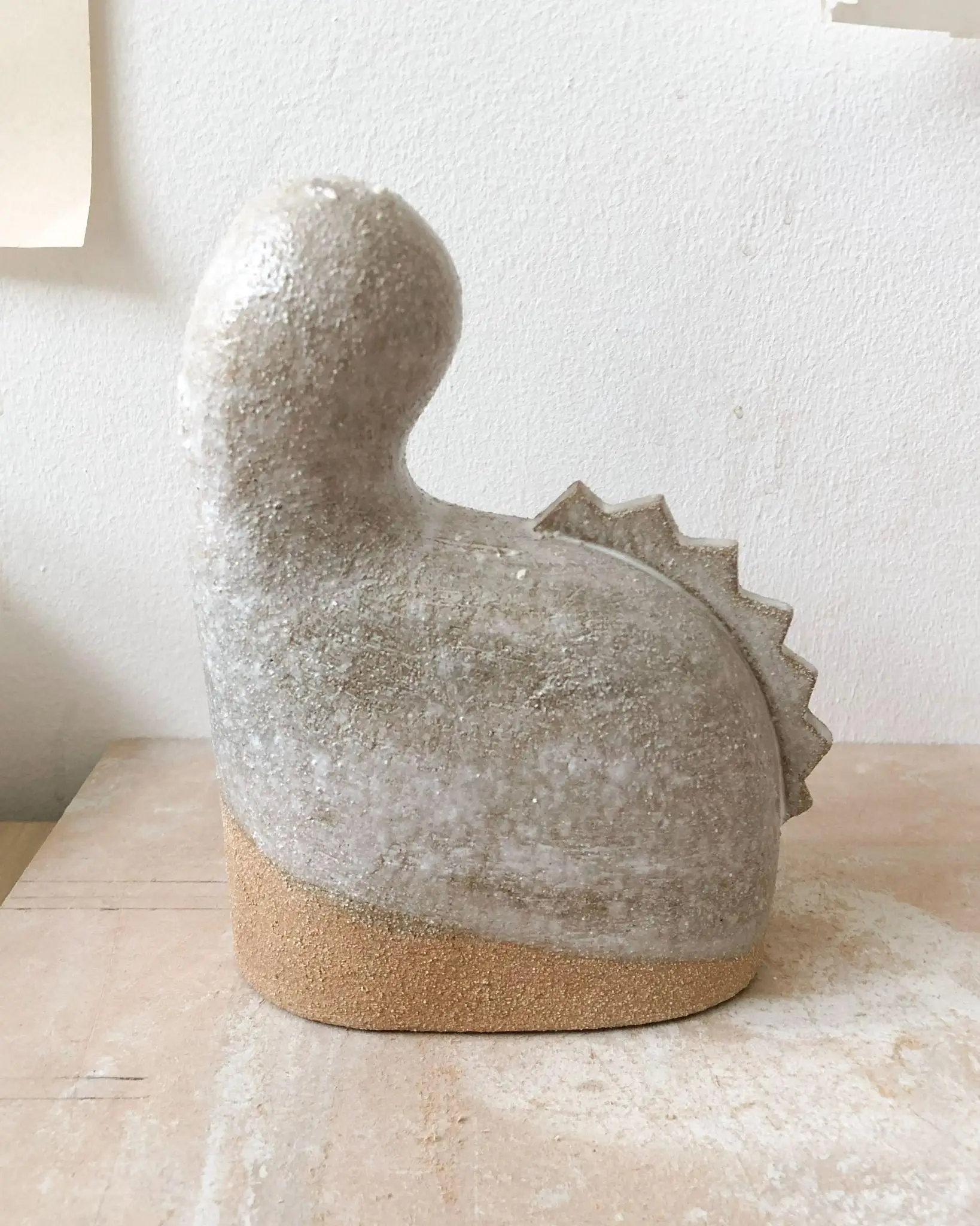 Petite sculpture Tiny #2 d'Elisa Uberti en grès émaillé gris, forme sinueuse évoquant un animal stylisé, base en grès brut