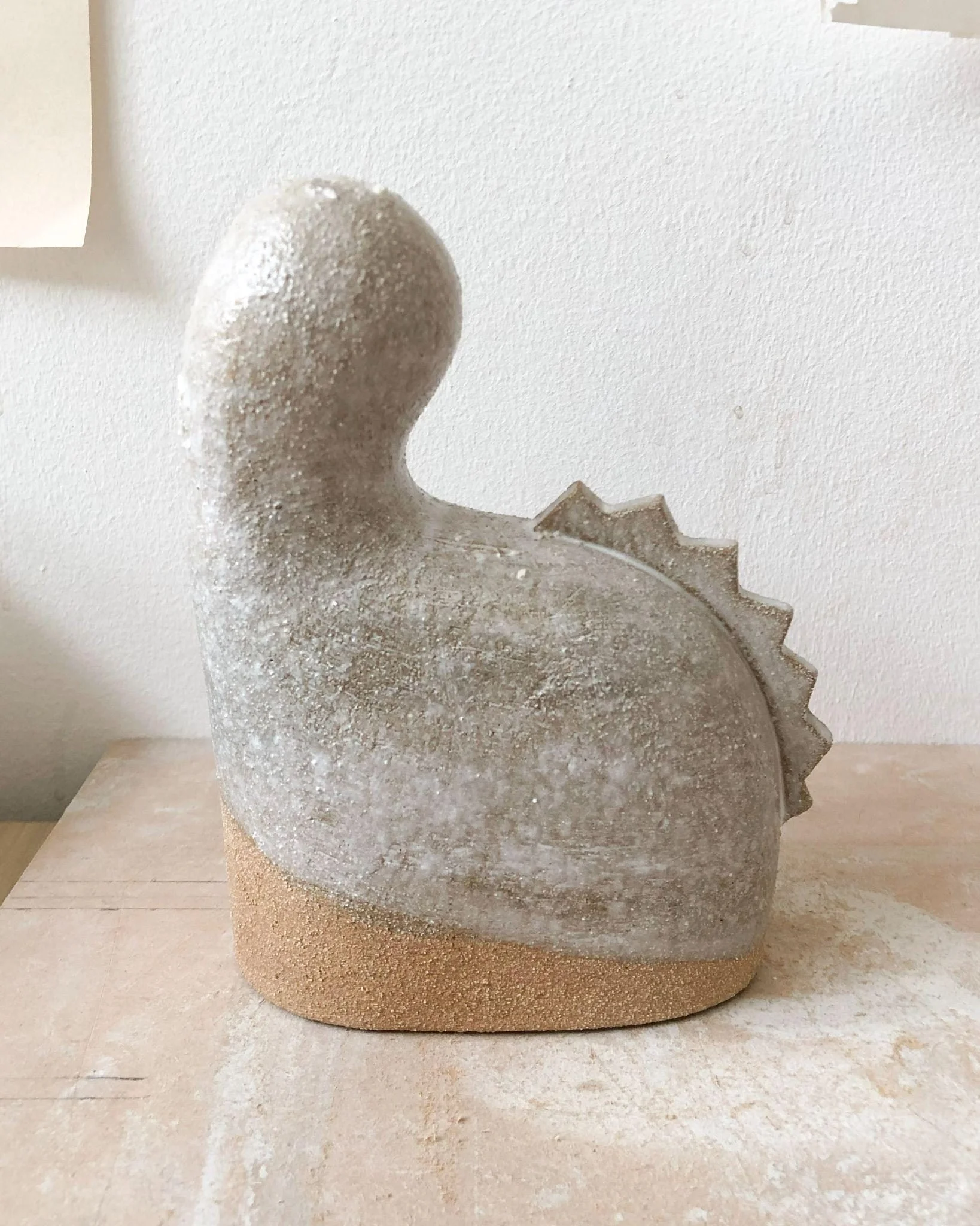 Petite sculpture Tiny #2 d'Elisa Uberti en grès émaillé gris, forme sinueuse évoquant un animal stylisé, base en grès brut